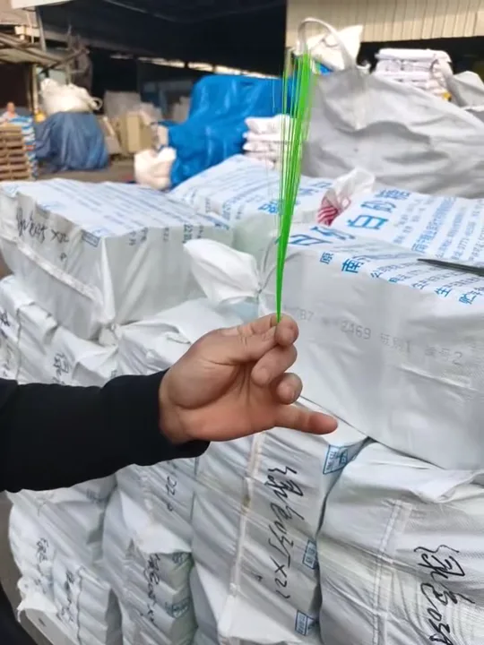 Operador probando por flexión el filamento PET verde para comprobar su elasticidad